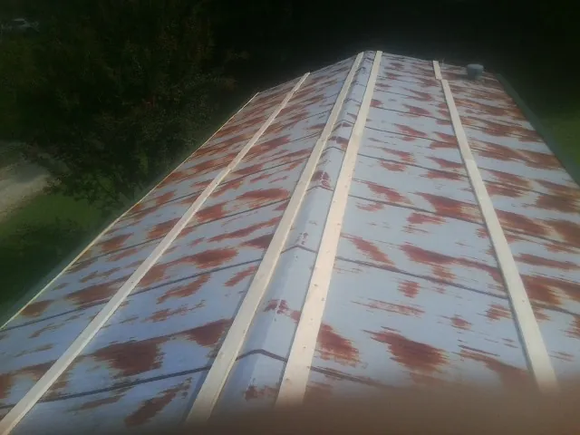 Rusted metal roof panels with new wood purlins before replacement — Storm Damage Roof Repair in Loretto by Roofing Brothers